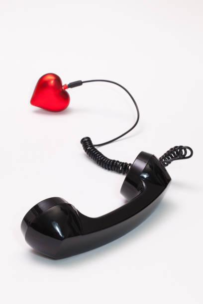 istock Old phone reciever and cord connection with red heart 666943338
