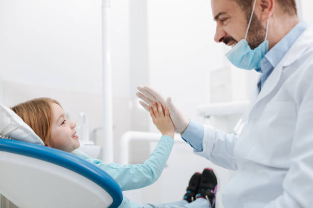istock Cheerful great dentist giving his little patient a high five 666943626