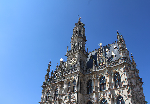 The beautiful 14th century, late gothic style Oudenaarde Town Hall,  in East Flanders in Belgium. Against a background of blue sky with copy space.