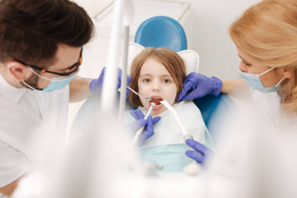 istock Enduring adorable girl sitting at dentists chair 666951232