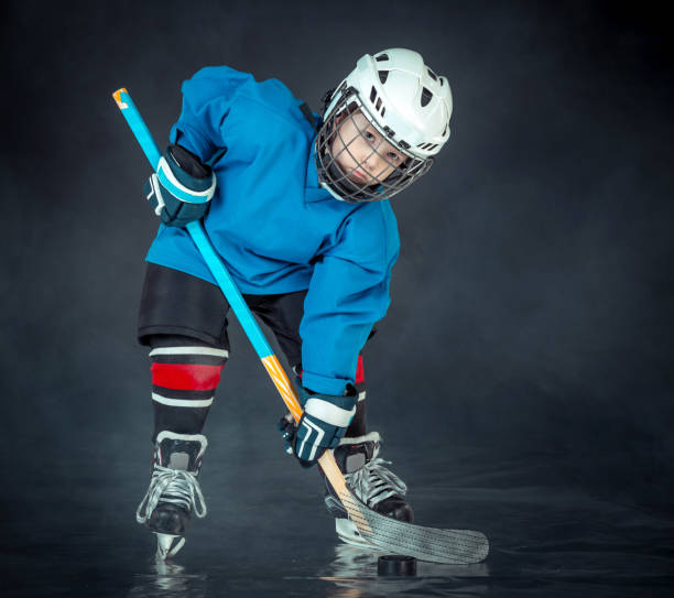 istock Boy Hockey Player Poses To Portrait 666954814