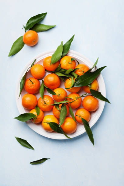 istock Tangerines with green leaves on vintage blue table. Flat lay style. 666960260