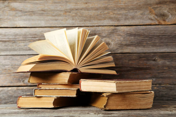 istock Old antique books on grey wooden table 666960974