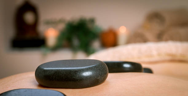 masażysta masujący ramiona i plecy mężczyzny z gorącymi kamieniami bazaltowymi - lastone therapy men spa treatment male zdjęcia i obrazy z banku zdjęć