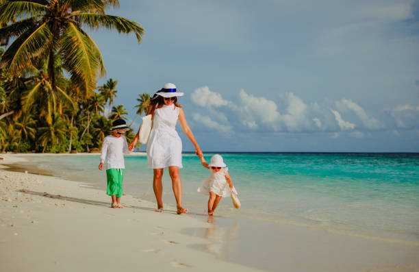 istock mother with little son and daughter walk on beach 666964808