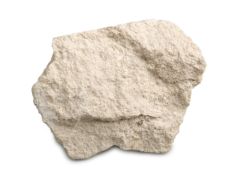 Piedra caliza aislada sobre fondo blanco. La piedra caliza es una roca sedimentaria compuesta por fragmentos esqueléticos de organismos marinos. photo