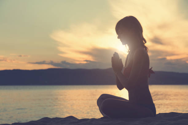 istock Young woman practicing yoga on the beach. 666981092