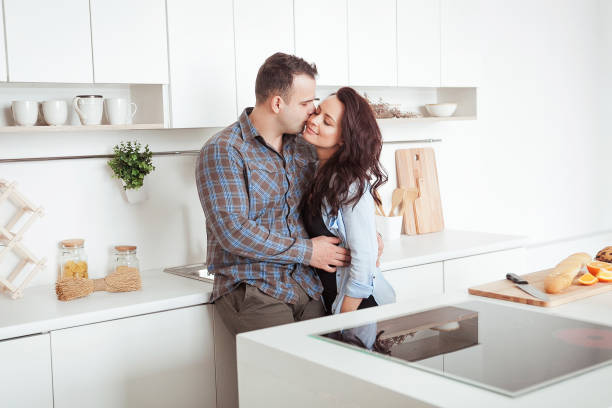 istock Happy couple hugging in the white loft stile kitchen 666987464