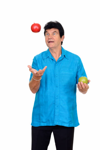 istock Happy mature man holding green apple and throwing red apple 666996142