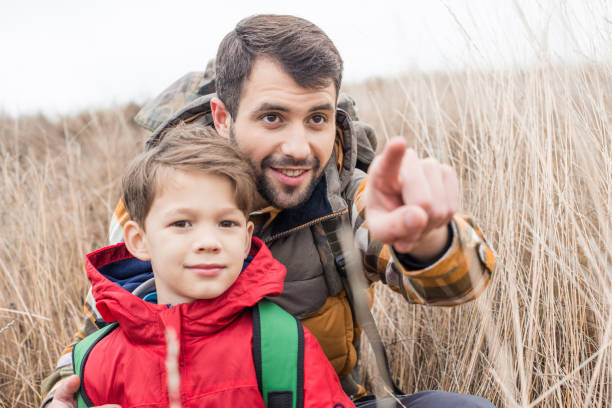 istock Father with son sitting in grass 666998356
