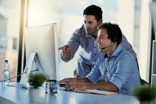 Cropped shot of two call centre agents working together in an office