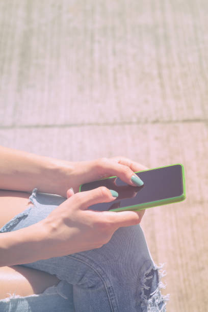 istock Girl texting while sitting on the bench outdoors. 667002030
