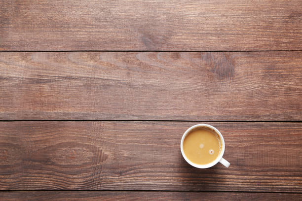 istock Cup of coffee on a brown wooden table 667002394