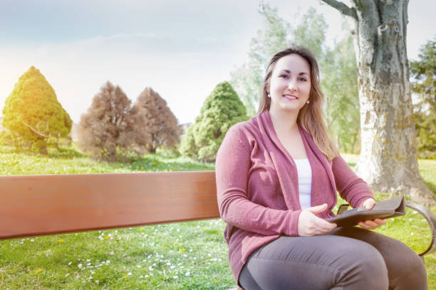 istock Beautiful young woman using digital tablet outdoors 667002538