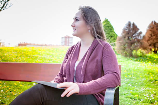 istock Beautiful young woman using digital tablet outdoors 667002542