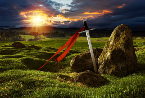 Sword in the dramatic sunny landscape. Sword on the meadow with stones under the dramatic sky. Storm heaven and sun lights. Photos montage with 3D render illustration. arthurian legend stock pictures, royalty-free photos & images