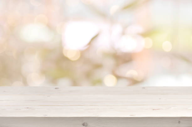 istock Wooden table in front of abstract blurred summer lights background 667009286