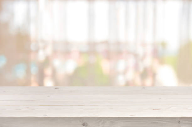 istock Wooden table in front of blurred transparent window curtain background 667009352