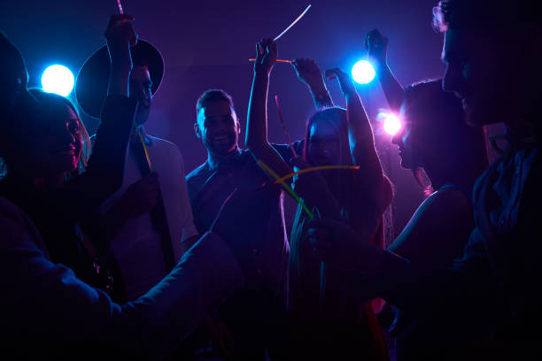 Clubbers Having Fun with Glow Sticks Young people enjoying dancing in night club with glow sticks in their hands glow stick stock pictures, royalty-free photos & images