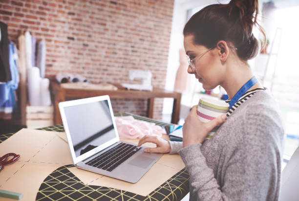 istock Tailor checking fashion news on laptop 667024340