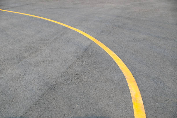 istock Yellow curve Traffic line on road floor texture and background 667027596
