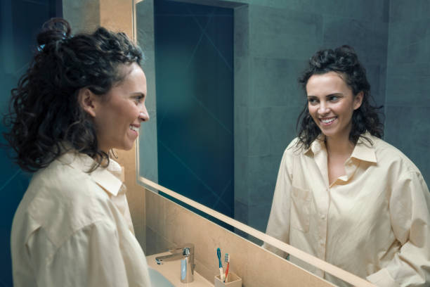 istock Woman applying makeup in mirror 667033058