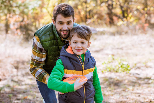 istock Smiling father and son playing with frisbee 667039214