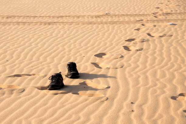 istock Kick off shoes and walking on white sand. 667048378