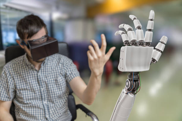 jeune homme contrôle main robotisée avec casque de réalité virtuelle. - artificial metal healthcare and medicine technology photos et images de collection