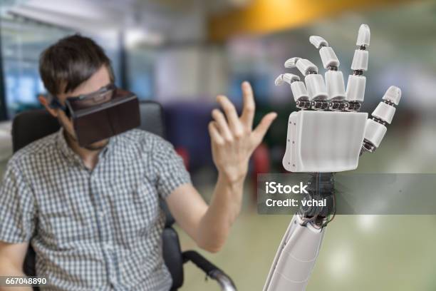 Young Man Is Controlling Robotic Hand With Virtual Reality Headset Stock Photo - Download Image Now