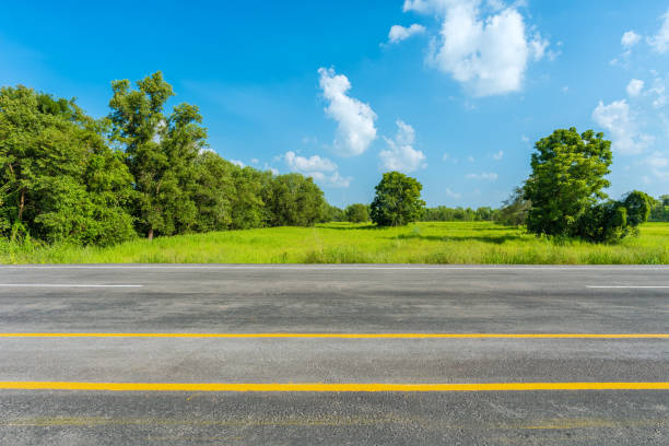 istock asphalt road and green rice field 667050164