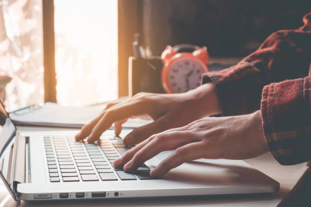istock Man's using laptop with blank screen on desk in home interior. Business concept 667056000