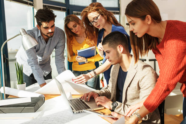 istock Designer and his friends working on new project . 667056588