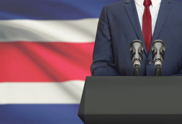 Businessman or politician making speech from behind a pulpit with national flag on background - Costa Rica stock photo