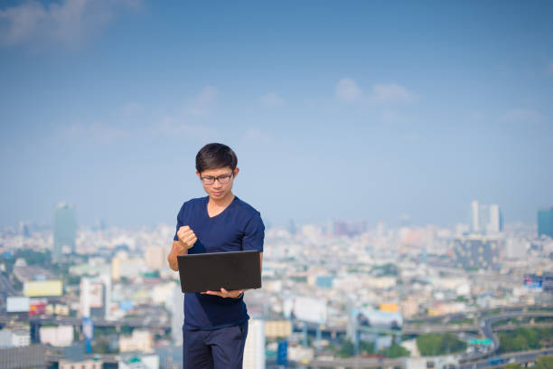istock Young business man using laptop and digital tablet cityscape background 667063636