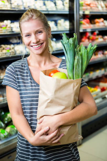 istock Beautiful woman standing with grocery bag 667066790