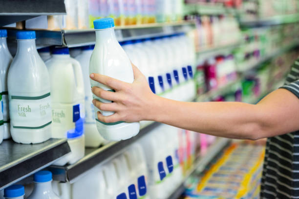 istock Womans hand holding milk bottle 667067610