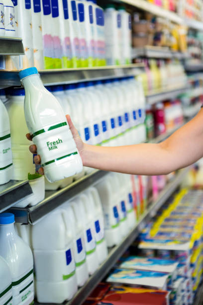 istock Womans hand holding milk bottle 667067704