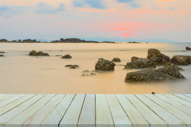 istock Empty wooden table or shelf wall with  sunset or sunrise on sand beach background. For present your products. 667070288