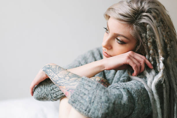 istock Young woman with tattoos contemplating 667074928