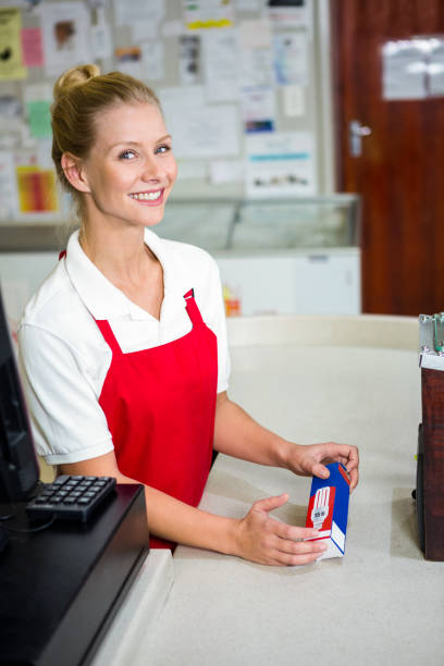 istock Smiling shop assistant looking at product 667076080
