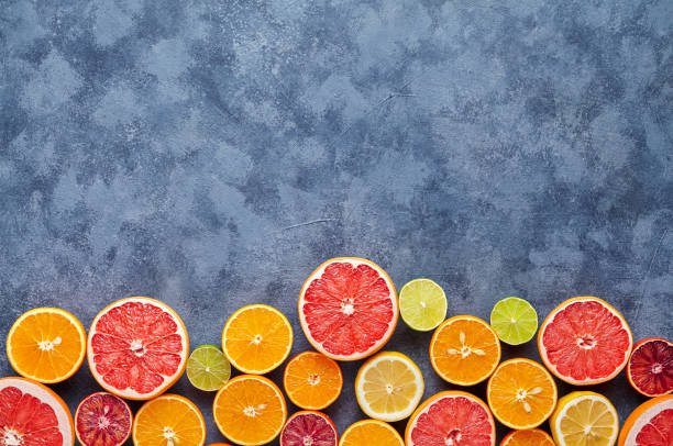 istock Different citrus fruit on dark grey concrete table. Fruit food background. Healthy eating. Antioxidant, detox, dieting, clean eating, vegetarian, vegan, fitness or healthy lifestyle concept 667076750