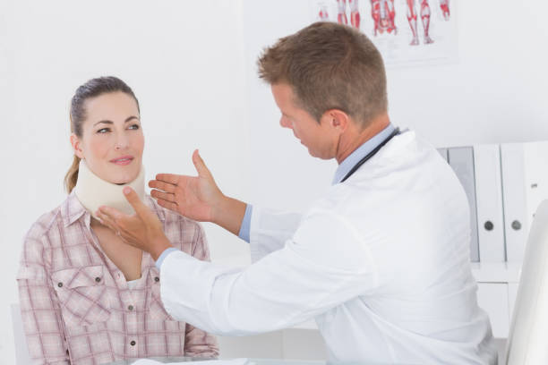 istock Doctor examining patient wearing neck brace 667083878