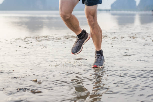 istock Young asian man running on beach with sunset in background 667084142
