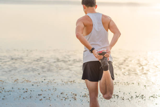 istock Young asian man running on beach with sunset in background 667084198