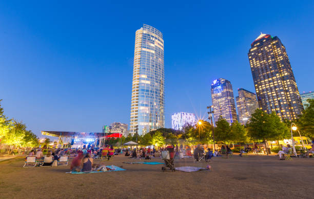 People are relaxing and picnicking in free music in the park event in Klyde Warren Park, uptown Dallas, TX stock photo