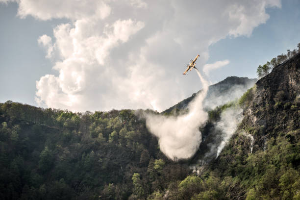 avion de pompier éteindre un feu sur la forêt de montagne - airplane stunt yellow flying photos et images de collection