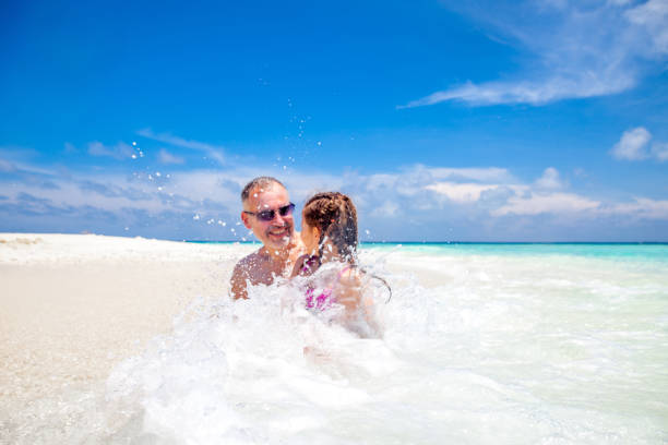 istock Father And Daughter Relaxing On The Tropical Beach 667090970