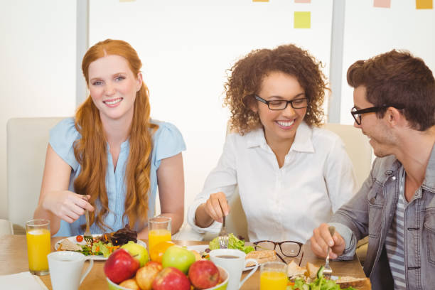 istock Businesswoman having lunch with colleagues 667091398