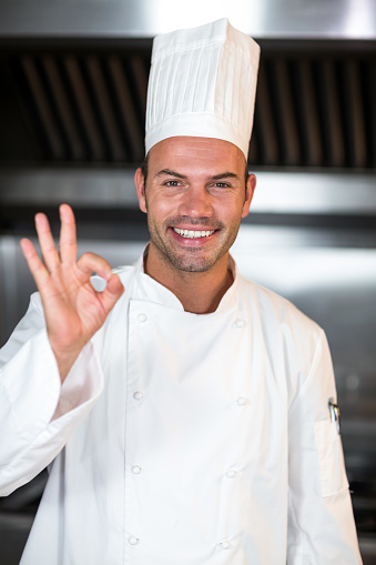 Portrait of chef gesturing ok sign in a commercial kitchen